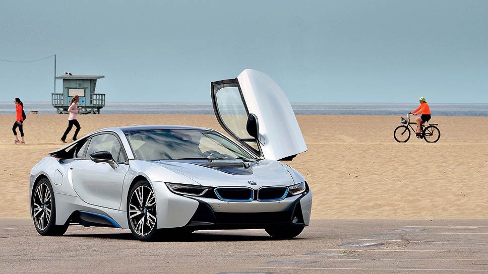 BMW i8 с распахнутыми дверями-крыльями смотрится очень внушительно и грациозно. Между тем двери выступают вбок не более чем на 53 см. Опасения, что вы одних взмахом всех будете смахивать на парковке, напрасны.