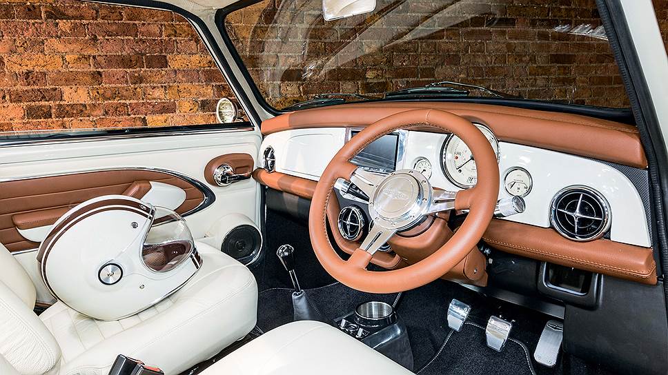 Приборная панель Mini воплощает в себе тонкое сочетание инноваций и классического стиля. Премиальные ретро-циферблаты Smiths здесь прекрасно уживаются с "утопленным" рулевым колесом Moto-Lita и крупным прямоугольным экраном мультимедийной системы. Любопытно, но в оригинальном автомобиле была пепельница, но не было полноценного подстаканника. Теперь же все встало на свои места.  