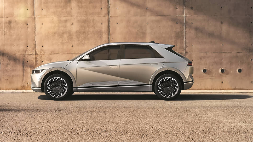 Hyundai Ioniq 5 внезапно крупный и потому гостеприимный. Чтобы выделить больше пространства для сидящих впереди, интерьерщики отказались от центральной консоли. Между креслами придумано разместить объемный сдвижной бокс 