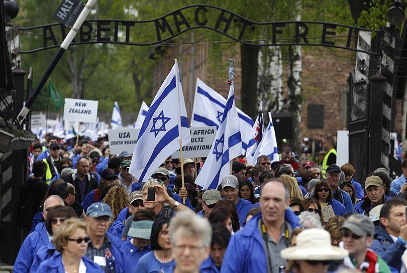 Лагерный комплекс Освенцим (Auschwitz) был создан нацистами на территории Польши в апреле 1940 года. Включал три лагеря. На территории комплекса было уничтожено около 1,1 млн человек. На момент освобождения 27 января 1945 года войсками 1-го Украинского фронта в лагерях оставалось 7 тыс. заключенных. В 1947 году сейм Польской Народной Республики объявил территорию комплекса Памятником мученичества польского и других народов, 14 июня был открыт музей Аушвиц—Биркенау. Национальные экспозиции, размещенные в отдельных бараках, включают досье и личные вещи узников из более чем 30 стран. В 2007 году в Польше была закрыта российская экспозиция в музее Освенцима, причем дирекция музея была готова открыть ее только в том случае, если российская сторона признает оккупацию польских территорий СССР. В России отреагировали на инициативу руководства Освенцима как на политический демарш На фото люди проходят через ворота, на которых написано Arbeit Macht Frei («Работа освобождает»), на территории бывшего нацистского лагеря смерти Освенцим