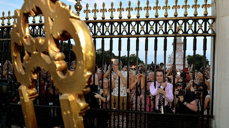 Британцы и туристы перед зданием Букингемского дворцы 