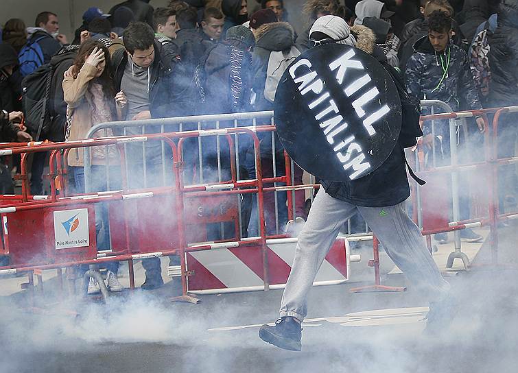 2016 год. Протесты против трудовой реформы в Париже. Участник акции протеста с самодельным щитом с надписью «Убить капитализм» 