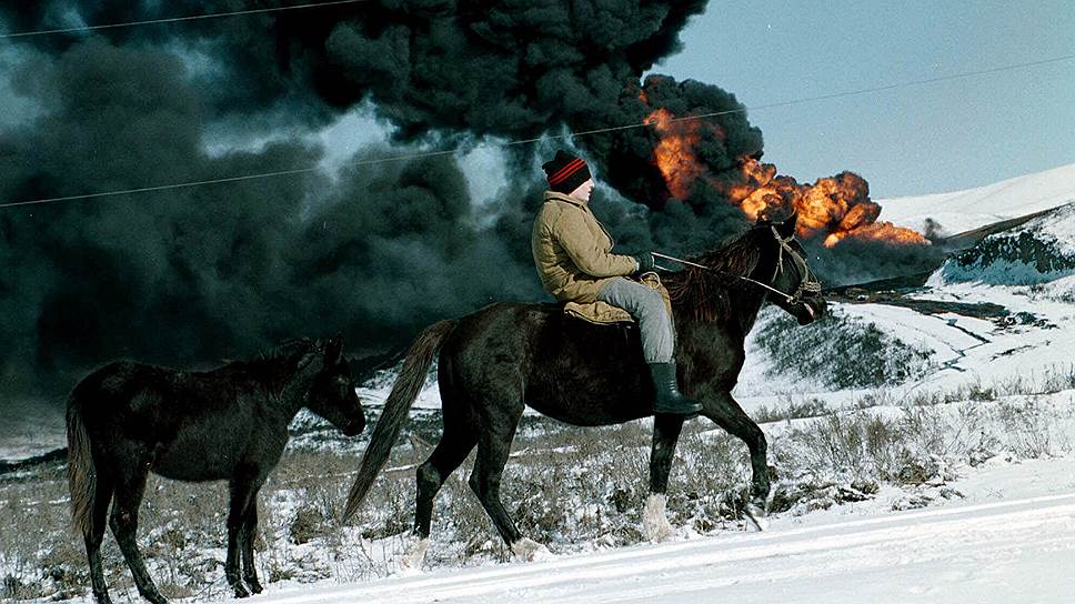 Январь 2000 года. Местный житель на лошади на фоне горящей нефтяной скважины в районе села Калаус