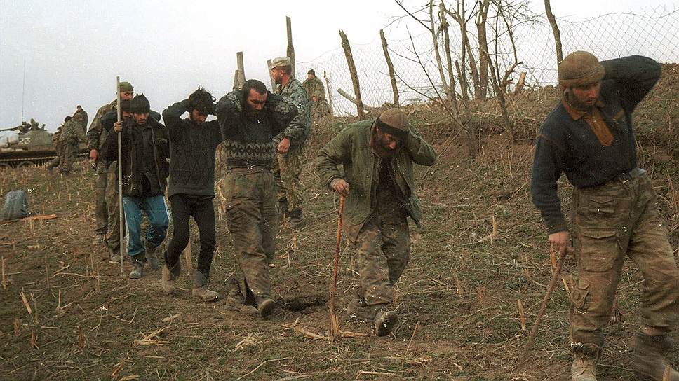 Март 2000 года. Солдаты конвоируют предполагаемых боевиков, взятых в плен после разгрома группировки в районе села Комсомольское к востоку от Грозного