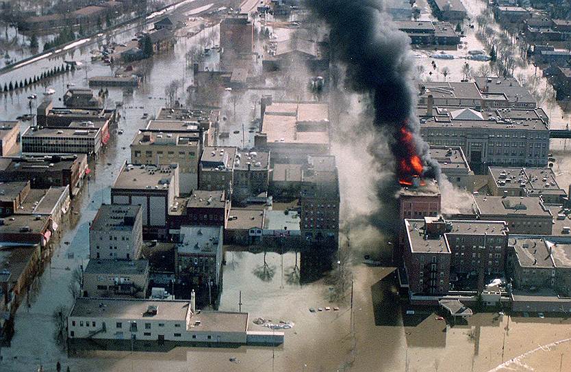 1997 год. В центре американского города Гранд-Форкс, страдающего от сильнейшего паводка, начинается пожар. Из-за наводнения спасатели не смогли вовремя приступить к тушению огня, в результате чего 11 зданий были уничтожены 