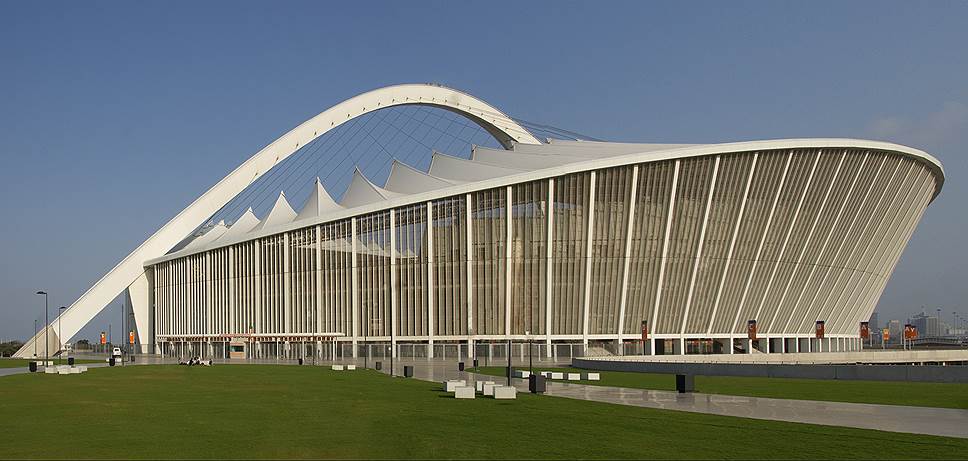 Стадион Мозеса Мабиды/Moses Mabhida Stadium Город: Дурбан, ЮАР Вместимость: 70 000 человек Год постройки: 2009 Стоимость строительства: $450 млн Описание: Стадион назван в честь генерального секретаря Южно-Африканской коммунистической партии Мозеса Мабиды. Эта арена принимала матчи чемпионата мира по футболу 2010 года. Главной особенностью конструкции стадиона является арка весом 2600 тонн и высотой 105 м, накрывающая его для поддержки крыши