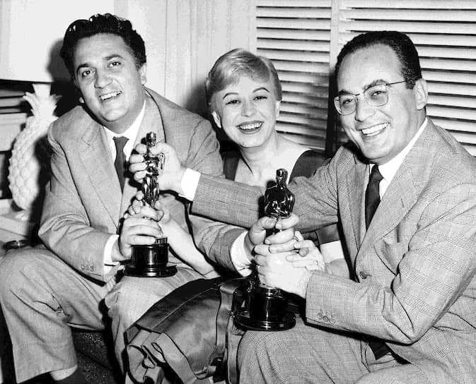 В 1949 году Федерико Феллини написал сценарий к фильму «Дорога», но пять лет не мог найти средства для съемок. После работы над этой картиной у режиссера случился психический надлом, который он сам позднее называл «Чернобыль души». Фильм ожидал оглушительный успех: более пятидесяти наград, в том числе «Серебряный лев» на Венецианском кинофестивале и «Оскар» \<br\>На фото (слева направо): Федерико Феллини, его жена Джульетта Мазина и кинопродюсер Дино Де Лаурентис 