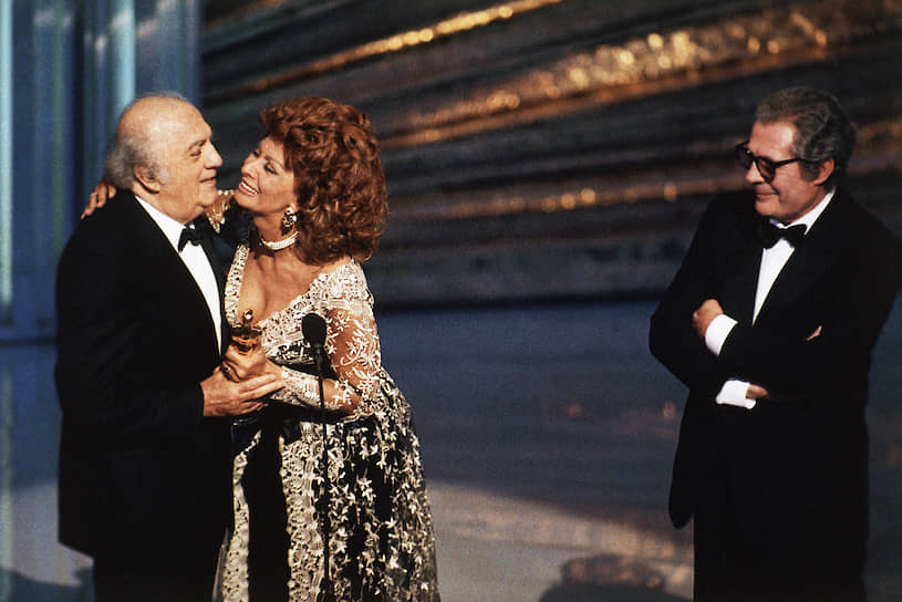 15 октября 1993 года Федерико Феллини госпитализировали с инсультом. 31 октября, через 50 лет и один день после свадьбы с Джульеттой Мазиной, Феллини скончался. Джульетта Мазина, больная раком легких, пережила мужа на пять месяцев. Перед смертью она выразила желание быть погребенной с фотографией Федерико в руке \<br\>На фото: актриса Софи Лорен и Федерико Феллини (слева) во время вручения режиссеру почетного «Оскара» за общий вклад в киноискусство