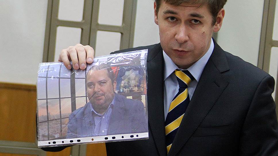Адвокат Надежды Савченко Илья Новиков с фотографией политконсультанта, члена Общественной палаты Москвы Павла Карпова