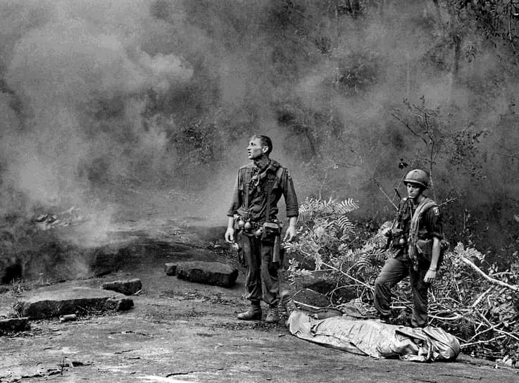 Пол Эпли. 1 октября 1966 года. «Американские военные в дыму ждут прибытия вертолета с медиками в джунглях» В 1965-1966 годах американские военные совместно с южновьетнамской армией развернули масштабное наступление в джунглях Южного Вьетнама. При этом широко использовались зажигательные средства, химическое и биологическое оружие 