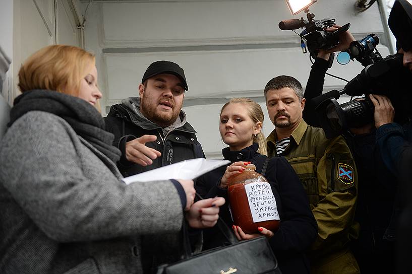 Муниципальный депутат Дмитрий Захаров (второй слева) и банка томатного сока, символизирующего кровь 