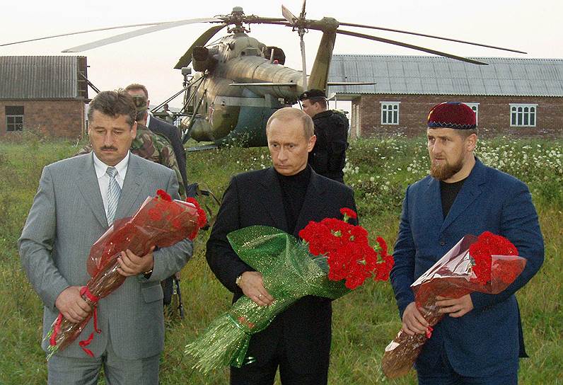 9 мая 2004 года при взрыве на стадионе в Грозном во время празднования Дня Победы погиб глава Чечни Ахмат Кадыров. Всего жертвами теракта стали семь человек. Ответственность за взрыв на себя взял лидер чеченских боевиков Шамиль Басаев. В 2006 году он был ликвидирован российскими спецслужбами На фото: президент РФ Владимир Путин (в центре), глава Общественного совета по контролю за восстановлением Чечни Алу Алханов (слева ), первый вице-премьер Чечни Рамзан Кадыров (справа) у могилы Ахмата Кадырова на кладбище в селе Центорой (должности указаны на 2004-й год)