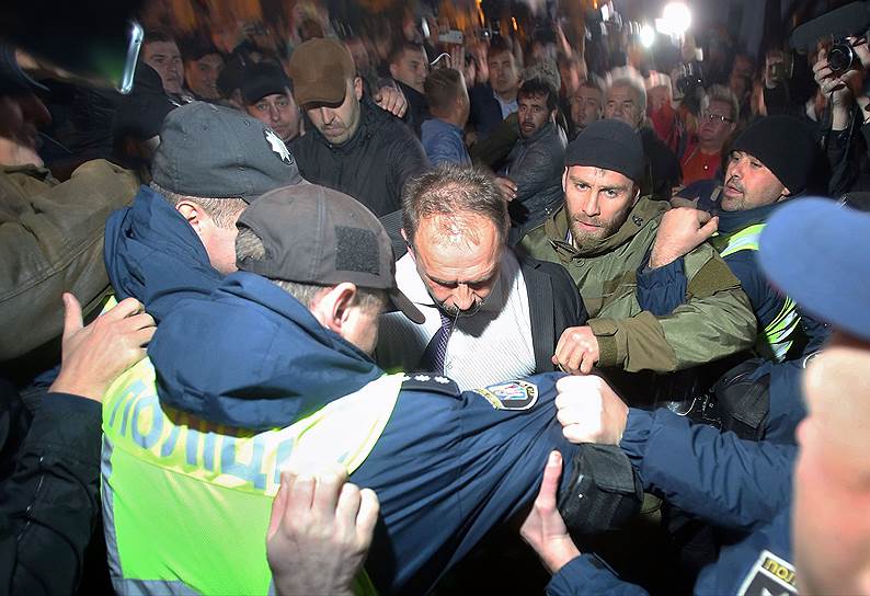 Народного депутата от Блока Петра Порошенко Олега Барну участники протеста и полиция уводят от Верховной Рады, где на него напали несколько неизвестных 