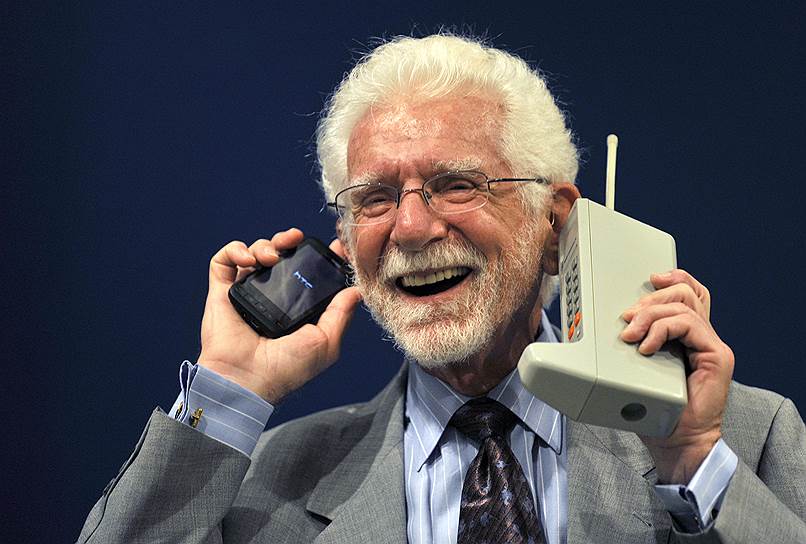В 1973 году был выпущен первый прототип портативного мобильного телефона — Motorola DynaTAC. Именно с него был совершен первый звонок. Вес устройства составлял почти 1,2 кг, на передней панели было расположено 12 клавиш — 10 цифровых и 2 для отправки вызова и прекращения разговора. Дополнительные функции и дисплей отсутствовали. В режиме ожидания телефон мог работать до восьми часов, в режиме разговора — около одного часа (по другим данным — всего 35 минут). Время зарядки составляло более десяти часов. До 1983 года было создано пять прототипов   На фото: Мартин Купер с современной моделью телефона и Motorola DynaTAC (справа), 2009 год 