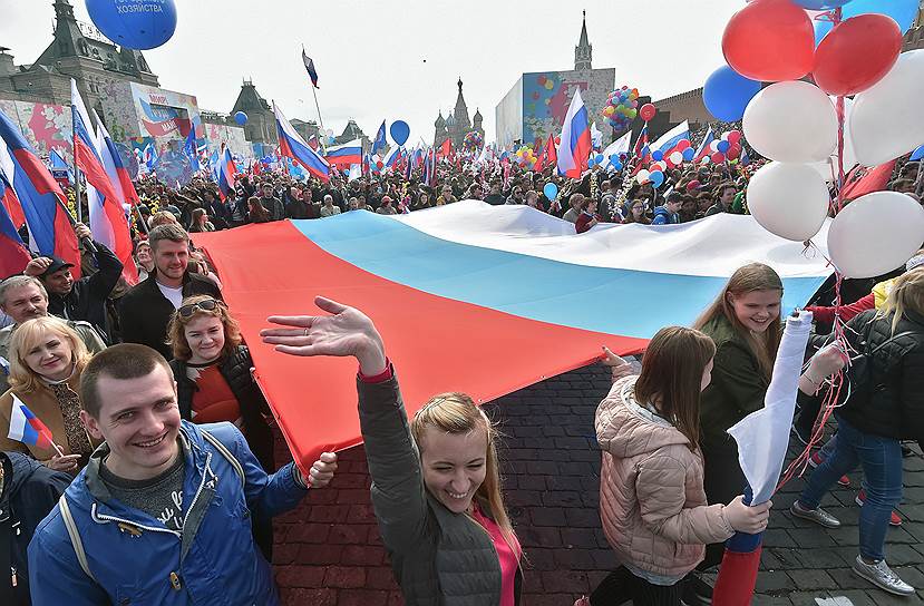 Участники шествия несут флаг России  