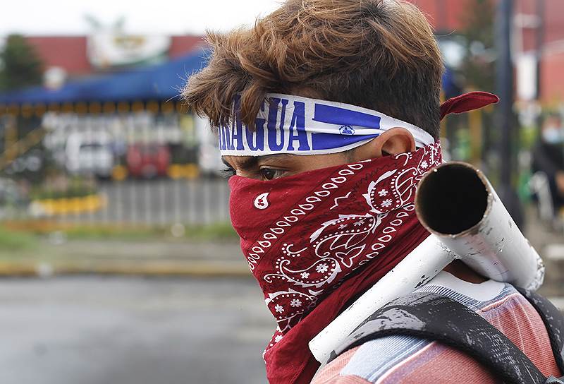 Демонстрант у здания Национального университета Никарагуа в Манагуа