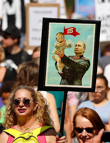 Участники акции протеста развернули плакат, на котором Владимир Путин держит на руках Дональда Трампа