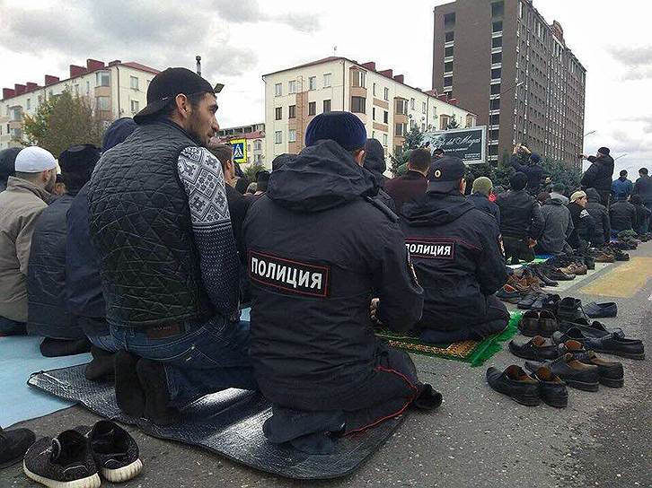 Участники и сотрудники полиции совершают пятничную молитву во время митинга