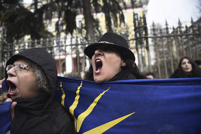 Протестующая держит флаг с Вергинской звездой - эмблемой античного греческого государства Македония и Александра Македонского 