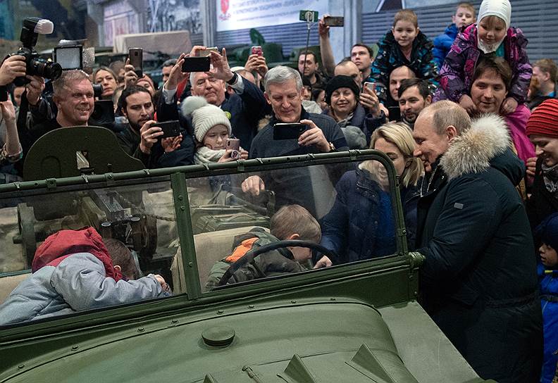 Президент России Владимир Путин (справа) во время осмотра выставочной экспозиции патриотического объединения «Ленрезерв» в день 75-летия полного освобождения Ленинграда от фашистской блокады