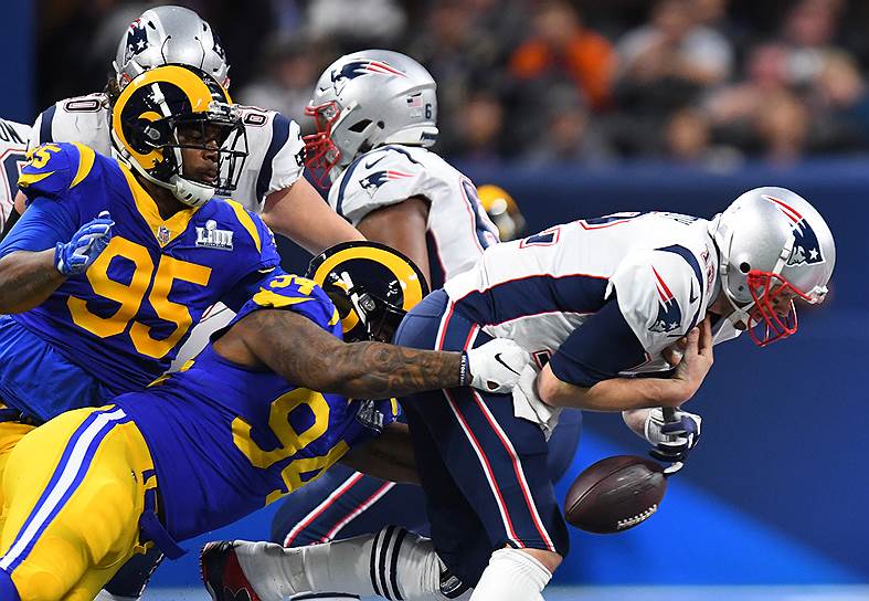 В финальном матче сезона Национальной футбольной лиги (NFL) «Нью-Ингленд Пэтриотс» взяли верх над «Лос-Анджелес Рэмс» со счетом 13:3   На фото: Том Брэди (12-й номер) и Джон Франклин-Майерс (94) 