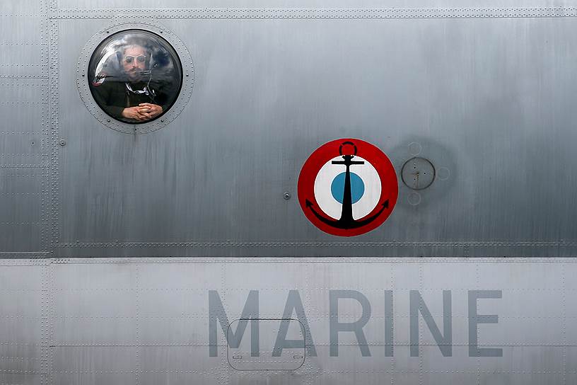 Член экипажа военно-морского флота Франции в иллюминаторе Breguet Atlantic — самолета ВМС дальнего радиуса действия, принятого на вооружение стран НАТО в 1964 году