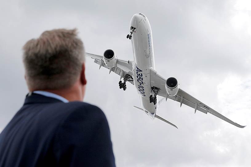 Посетитель наблюдает за демонстрационным полетом Airbus A350-1000