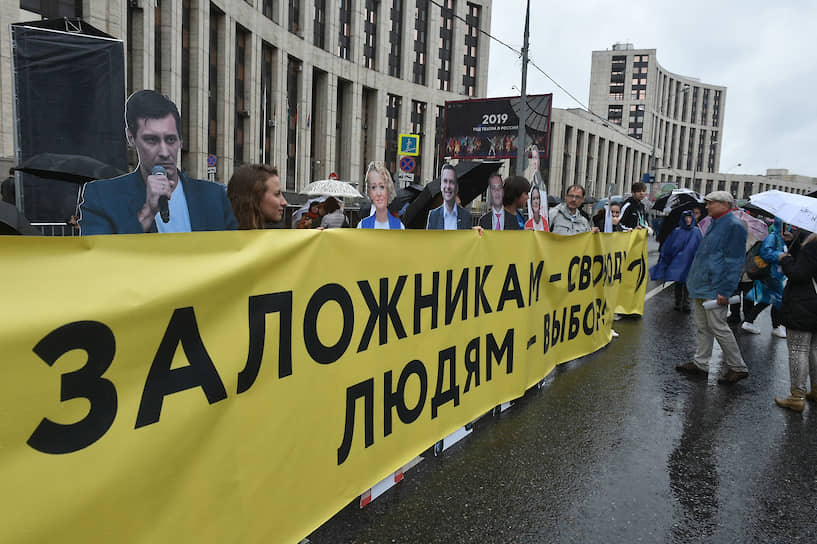 В центре проспекта поставили в ряд картонные фигуры арестованных незарегистрированных кандидатов в Мосгордуму — Дмитрия Гудкова, Илью Яшина, Юлию Галямину и других. Люди вставали между ними и держали желтый баннер «Заложникам — свободу, людям — выбор»