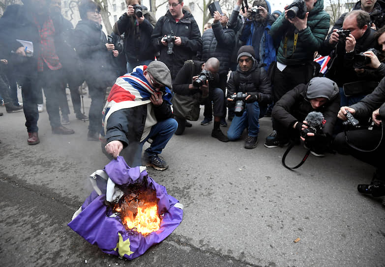 «Брексит» — калька с английского слова «brexit», объединившего слова «Britain» и «exit» (англ.— «выход»). Считается, что первым это слово в мае 2012 года использовал в своем микроблоге в Twitter глава исследовательского центра British Influence Питер Уилдинг  На фото: участник митинга сжигает флаг ЕС 