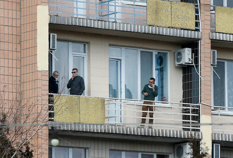Люди стоят на балконе медицинского центра Национальной гвардии Украины «Новые Санжары» 