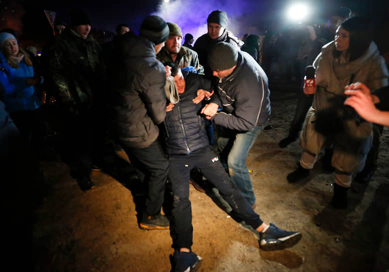 Демонстранты помогают одному из протестующих  