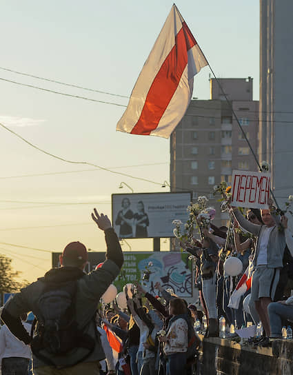 Участники акции в поддержку задержанных и пострадавших во время протестов 9 августа с флагом  