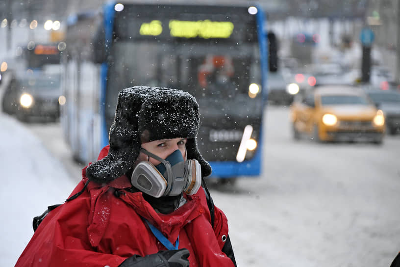 Женщина в респираторе на улице города 