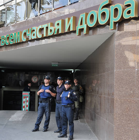 Сотрудники национальной полиции Украины в бронежилетах перед зданием с надписью «всем счастья и добра» в Одессе 