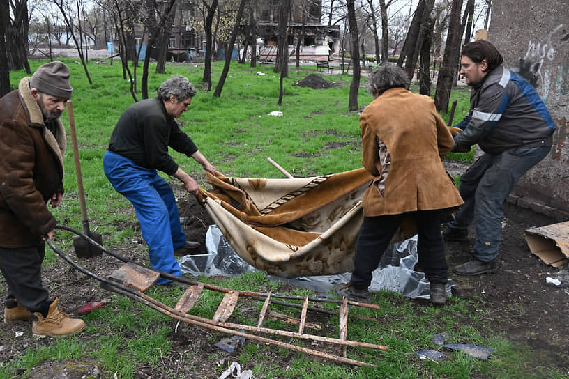 Последствия обстрела в Кальмиусском районе. Местные жители хоронят родственников во дворе жилого дома 