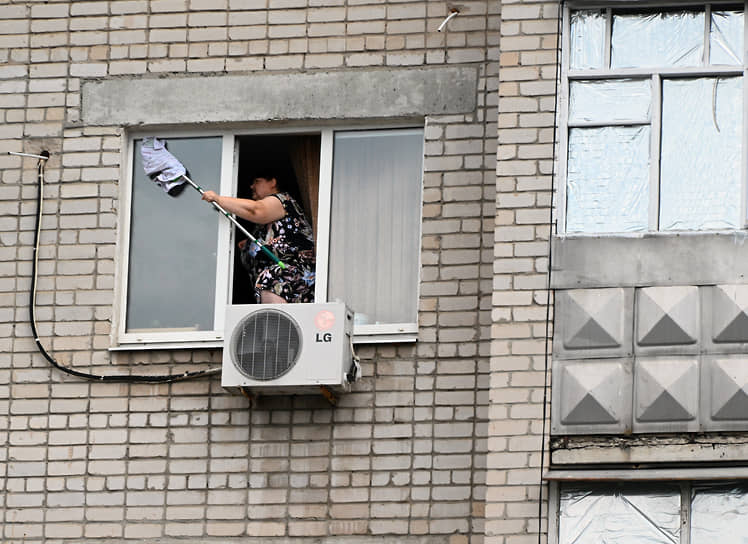 Жительница Мелитополя моет окно 