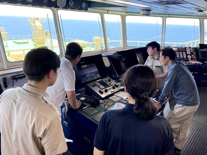 Капитан и его штурманы осматривают Avikus HiNAS совместного производства HD Hyundai Avikus и SK Shipping, первого в мире cудна, успешно осуществившего автономное плавание через океан 