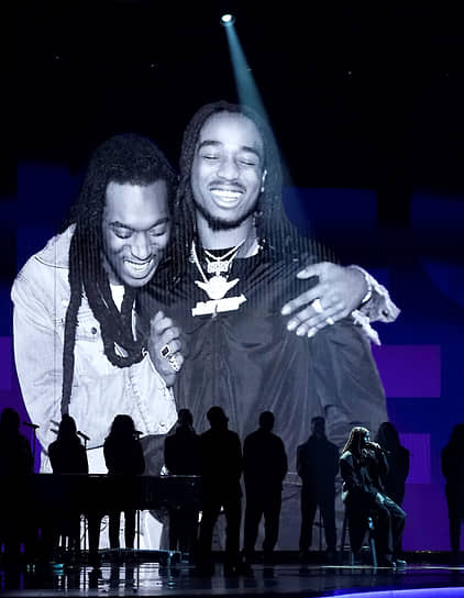 Американский рэпер Quavo (на экране справа) и музыкальный коллектив Maverick City Music исполняют песню «Without You» в честь Takeoff (на экране слева), покойного участника группы Migos