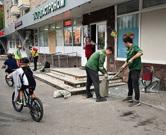 Сотрудники магазина убирают улицу