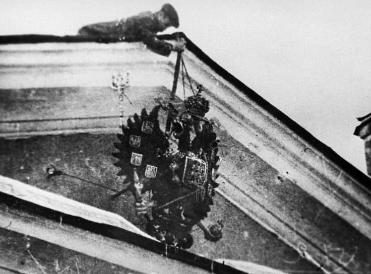 Революционер снимает устаревший герб. Март 1917 года 