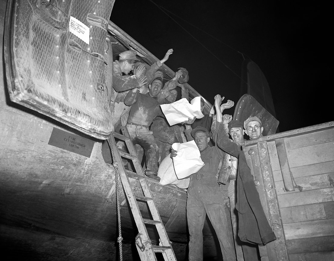 «Все ограничения будут отменены 12 мая 1949 г.» (на фото: грузчики аэродрома Темпельхоф с газетами, сообщающими об отмене транспортных ограничений. Берлин, 5 мая 1949 года)