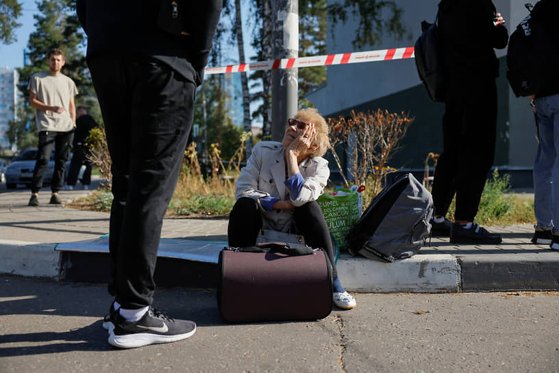 Местные жители у поврежденного дома 