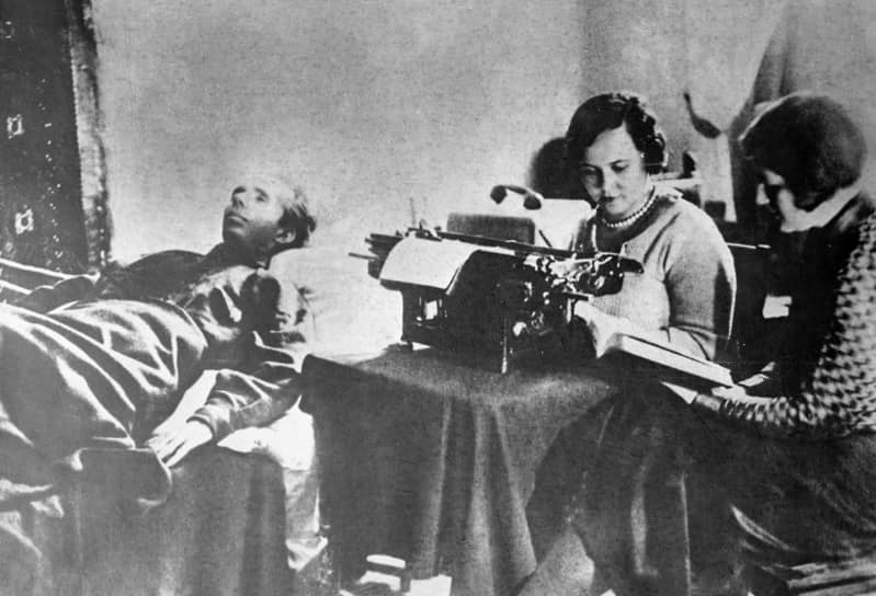 Николай Островский, лежа, диктует свою книгу машинистке и жене Раисе, 1935 год 