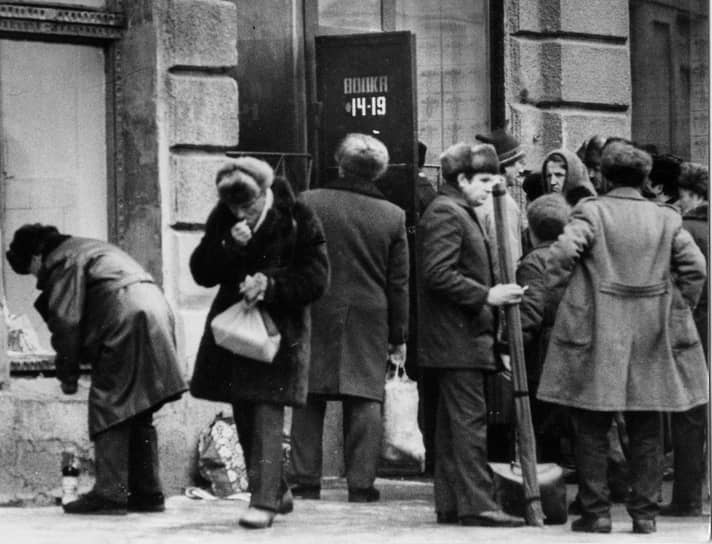 Первое, к чему привело сокращение производства водки и других спиртных напитков,— это очереди, в которых шумно критиковали советскую власть, а иногда даже дрались. На фотографии видно время работы магазина: с 14 до 19 часов, в соответствии с требованиями, узаконенными в мае 1985 года 
