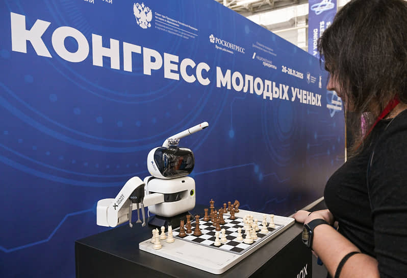 Робот-шахматист играет с посетителем выставки