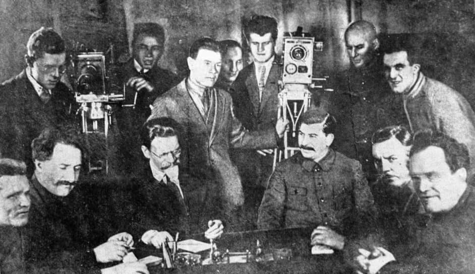 Слева направо в первом ряду высшее партийное руководства СССР конца 1920-х годов: Сергей Киров, Георгий Орджоникидзе, Михаил Калинин, Иосиф Сталин, Климент Ворошилов, Валериан Куйбышев. К этому моменту Ворошилов уже занимал пост Народного комиссара по военным и морским делам, позже переименованного в Наркомат обороны СССР