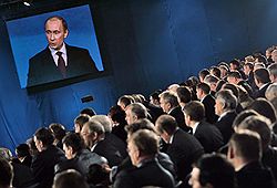Председатель правительства России Владимир Путин (на экране) во время выступления на XI cъезде партии "Единая Россия" 