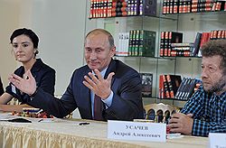 Писатель Алиса Ганиева (слева), председатель правительства России Владимир Путин (в центре) и писатель Андрей Усачев (справа) во время встречи с писателями и представителями Российского книжного союза