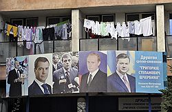 За желающими получить гражданство РФ с баннера в Косовска-Митровице наблюдают (слева направо) Александр Лукашенко, Дмитрий Медведев, экс-премьер Сербии Воислав Коштуница, Владимир Путин и Виктор Янукович