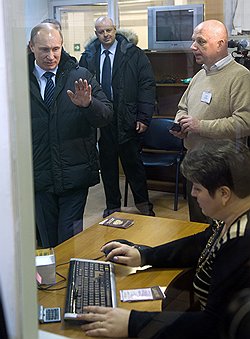 Председатель правительства России Владимир Путин (слева) и технический директор пункта технического осмотра автотранспортных средств Игорь Симаков (справа) во время посещения пункта технического осмотра автотранспортных средств в столичном районе Строгино